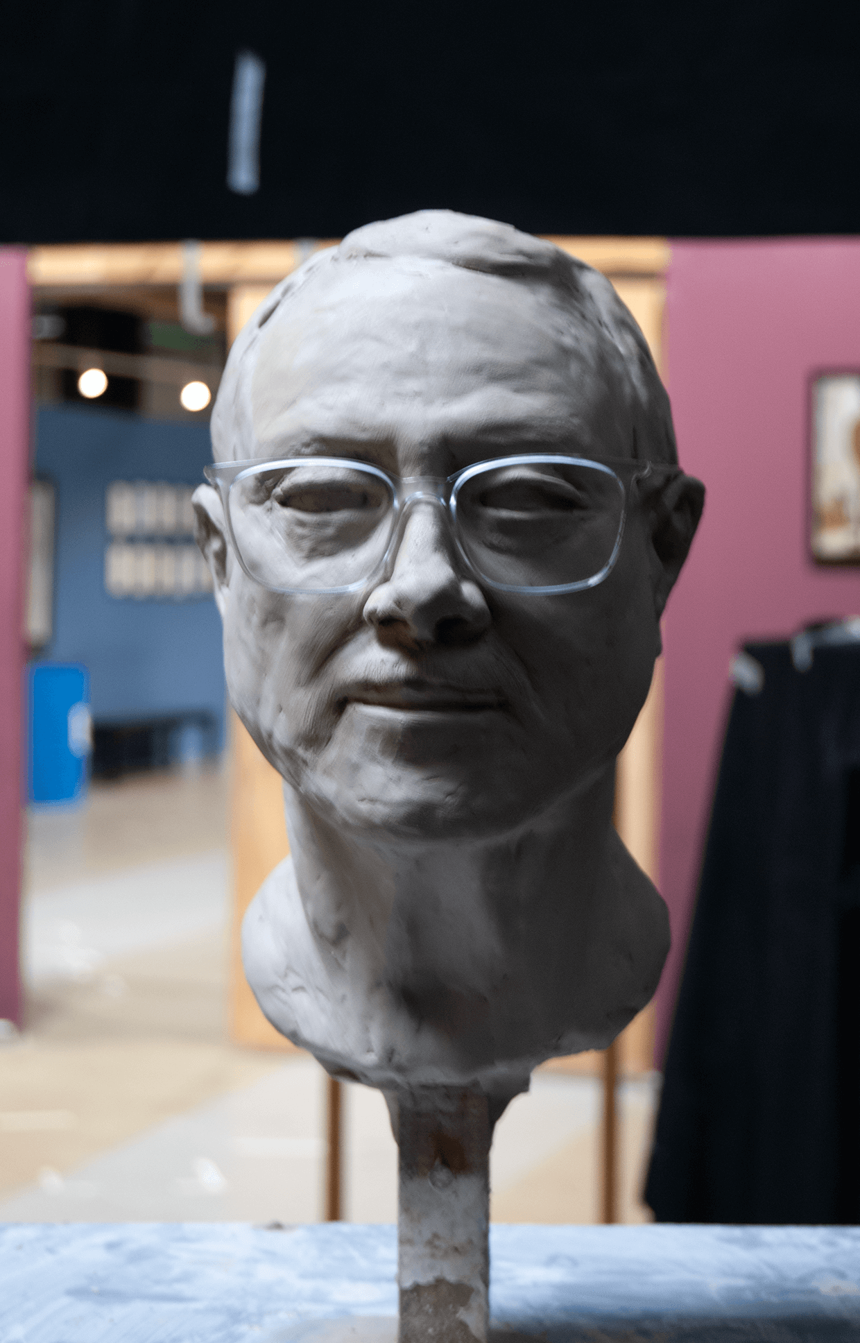 .Quique clay portrait sculpture with glasses.