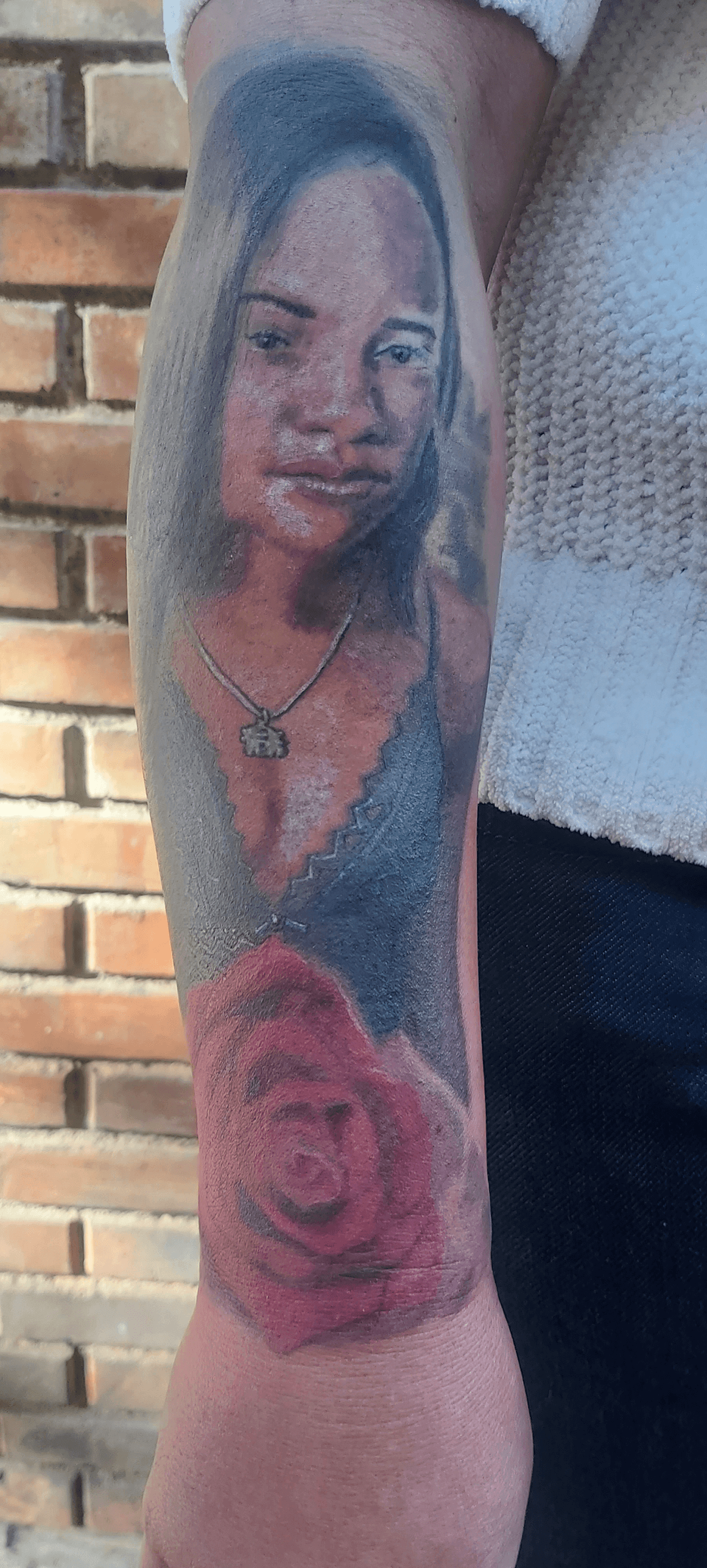 Bottom Half Sleeve Agatha portrait and rose color Tattoo on dark skin outdoor day after