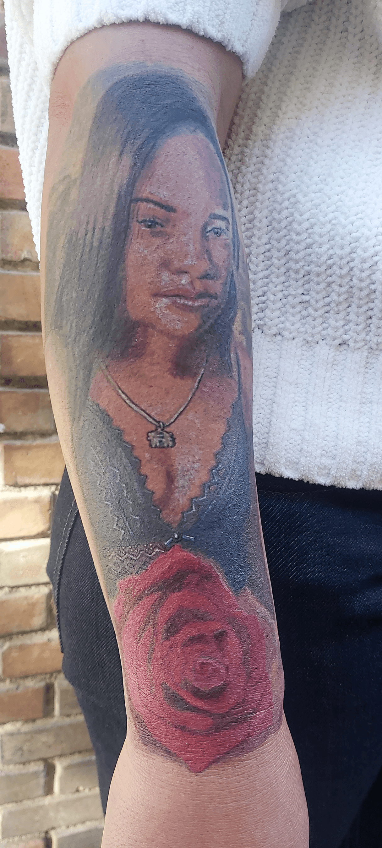 Bottom Half Sleeve Agatha portrait and rose color Tattoo on dark skin outdoor day after